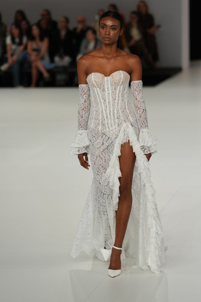 In questa foto la modella indossa un abito da sposa Claudio Di Mari 2026 con spacco e maniche removibili alla Barcelona Bridal Fashion Week