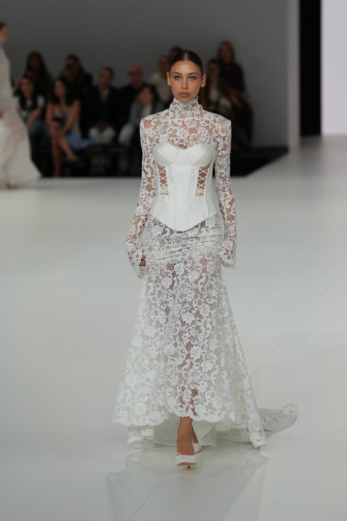 In questa foto la modella indossa un abito da sposa Claudio Di Mari 2026 con bustier e pizzo alla Barcelona Bridal Fashion Week