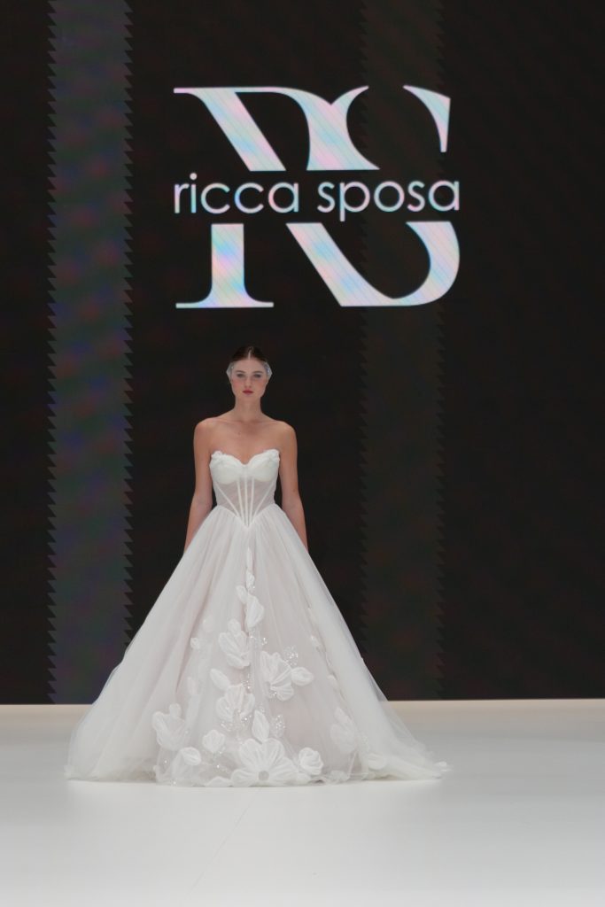 In questa foto la modella indossa in passerella un abito Ricca Sposa 2026 
