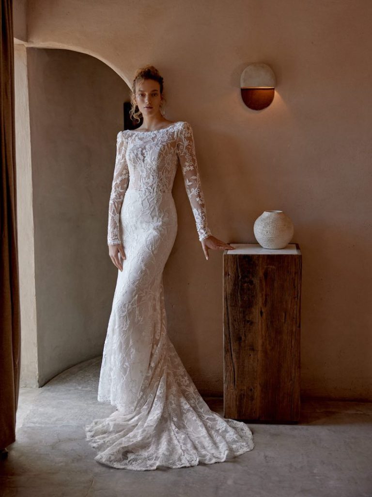 In questa foto, una modella indossa un abito a sirena in pizzo della collezione sposa Lilian West SS 2025