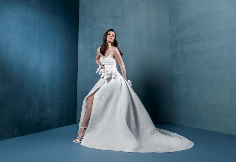 In questa foto, una modella indossa un abito da sposa ampio con spacco e fiori 3D Markisa 2026