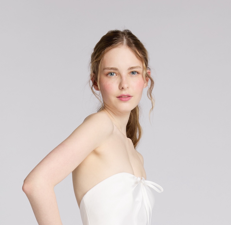 In questa foto, una modella indossa un abito da sposa di Antonio Riva e un trucco sposa naturale che punta l'attenzione sulle labbra dipinte con un rossetto rosato