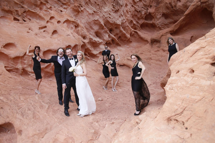 In questa foto una coppia di sposi nel deserto insieme a damigelle e testimoni