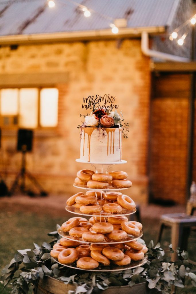 in questa foto un'originalissima donuts cake, la torta di matrimonio realizzata con le ciambelle glassate