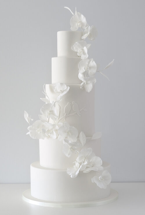 In questa foto una tipica torta nuziale all'americana, tutta bianca con una decoro di fiori ton sur ton