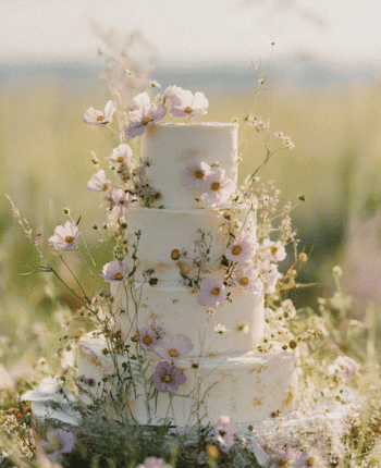 In questa foto una torta nuziale multipiano decorata con fiori di campo