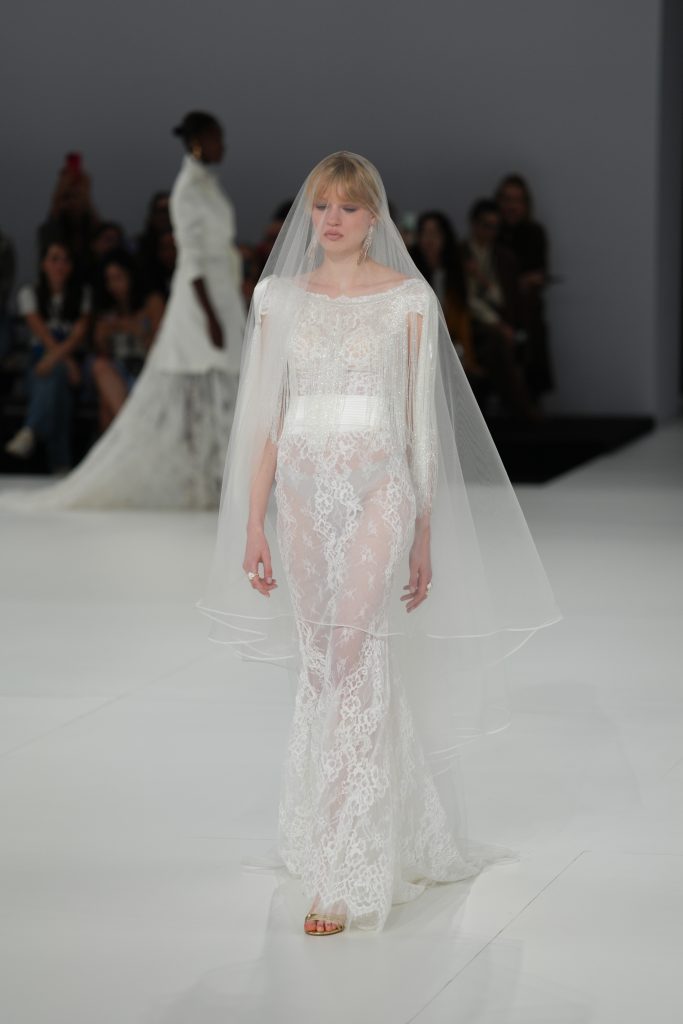 In questa foto la modella indossa un abito da sposa Helena 2026 di pizzo