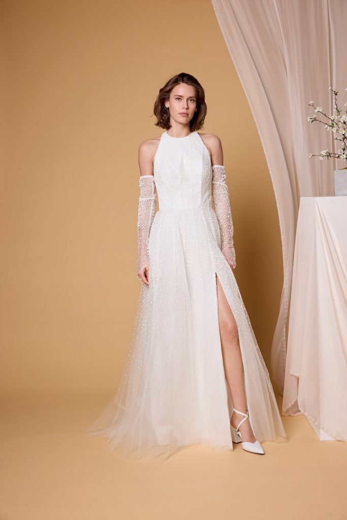 In questa foto, una modella indossa un abito da sposa scivolato in tulle e perline della collezione sposa Nagae 2026