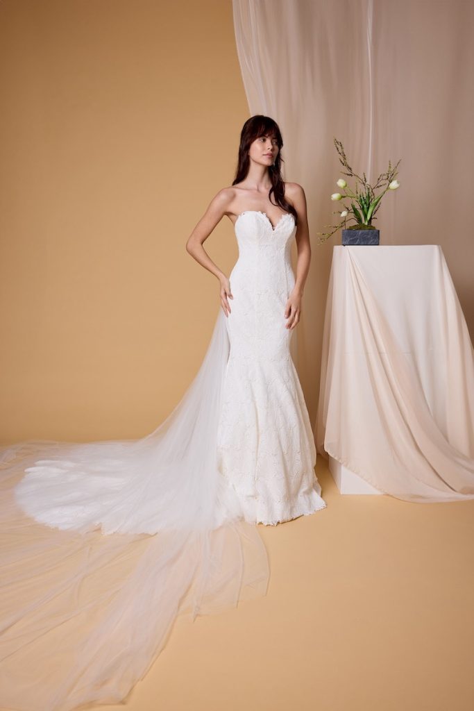In questa foto, una modella indossa un abito da sposa a semi sirena in broccato della collezione sposa Nagae 2026
