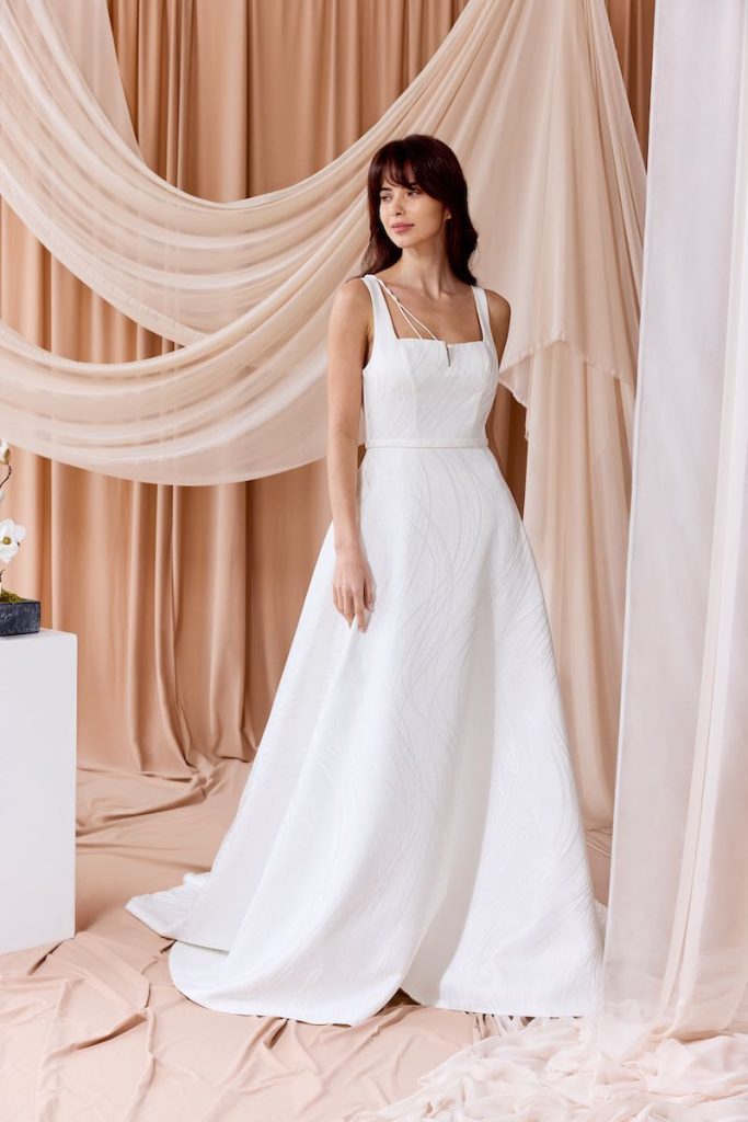 In questa foto, una modella indossa un abito da sposa ad A in jacquard della collezione sposa Nagae 2026