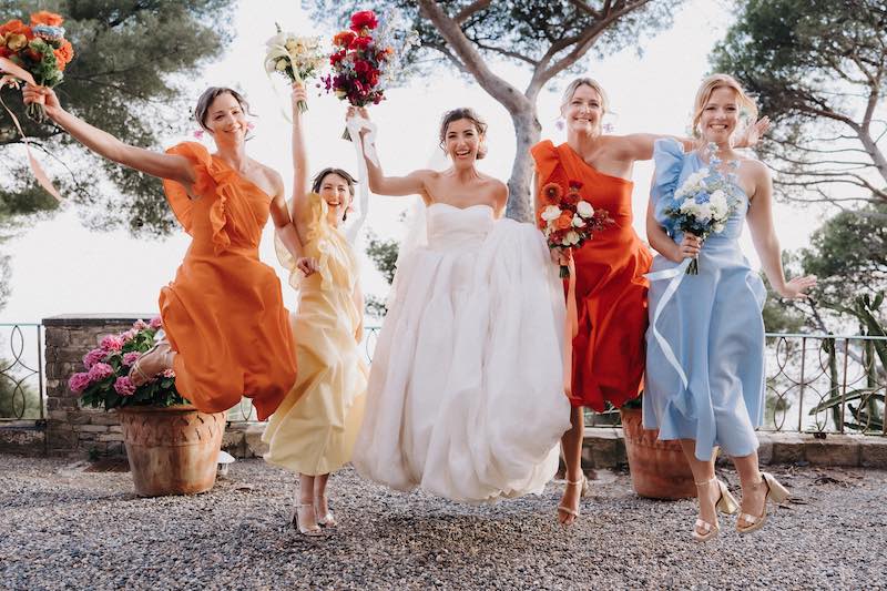 In questa foto una sposa che salta insieme alle sue damigelle 