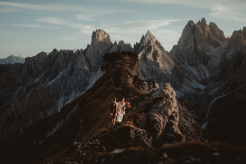 In questa foto di Federico Gritti due sposi che camminano sul dorso di una montagna durante il loro Elopement Wedding