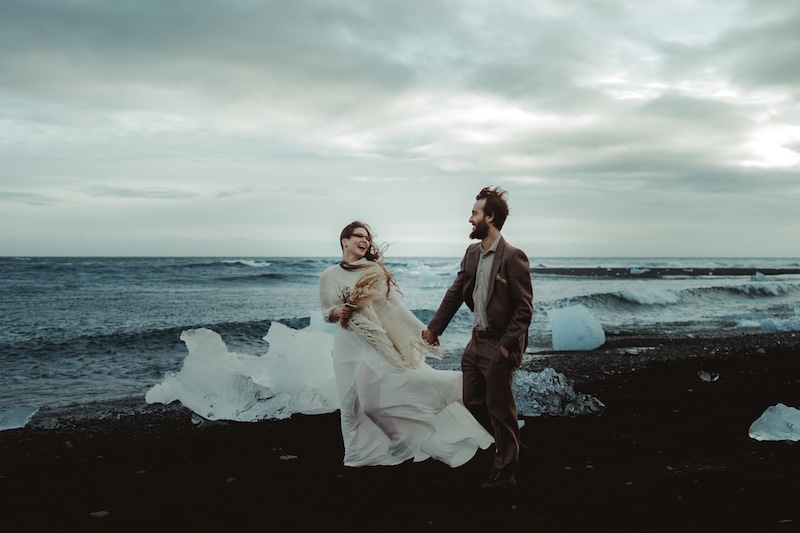 In questa foto di Federico Gritti due sposi che camminano tra i ghiacci su una spiaggia dell'Artico durante il loro Elopement Wedding