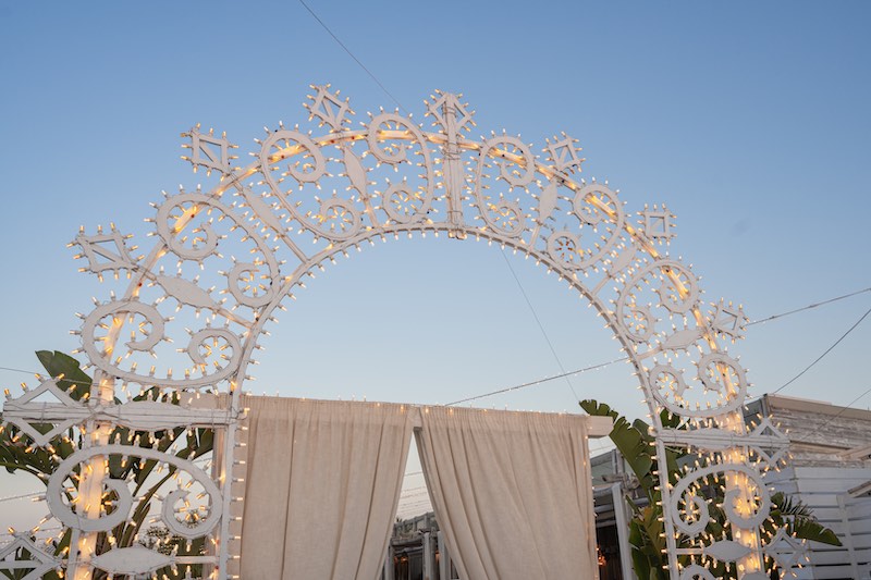 In questa foto, un arco di luci realizzato da Paulicelli per un matrimonio all'aperto