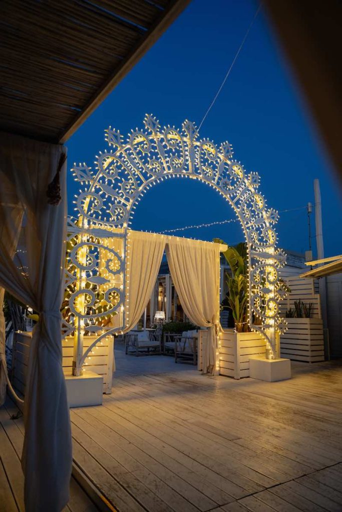 In questa foto, un arco di luci realizzato da Paulicelli per un matrimonio all'aperto