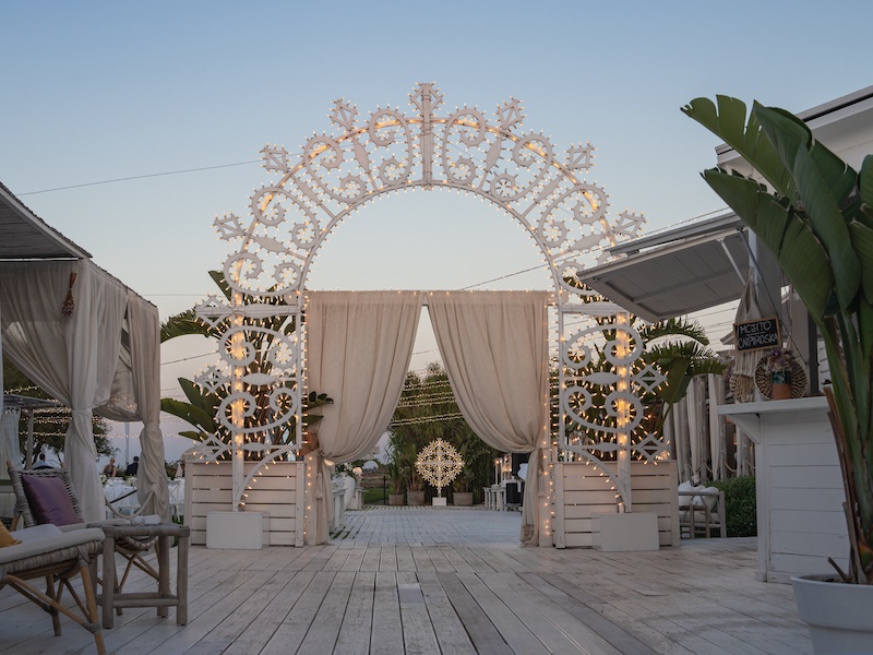 In questa foto, un arco di luci realizzato da Paulicelli per un matrimonio all'aperto