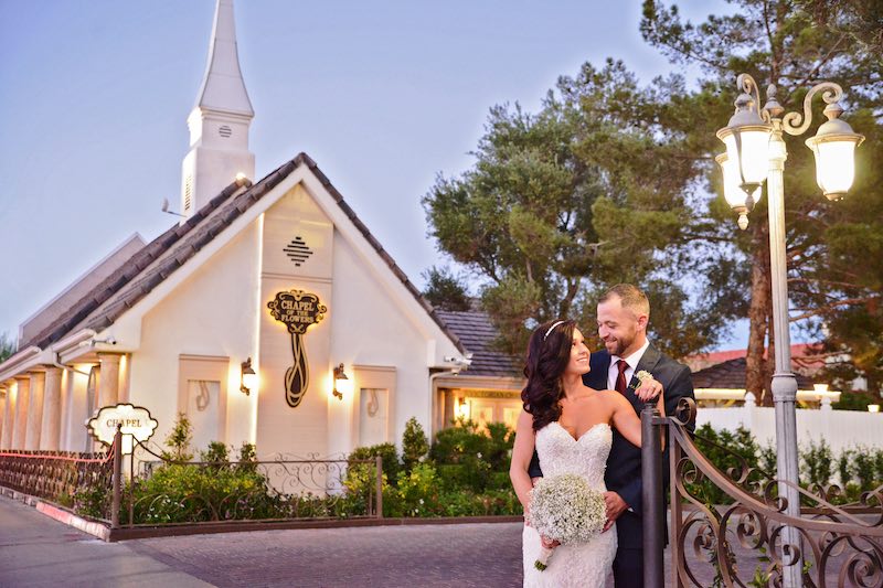 In questa foto, due sposi si guardano innamorati vicino ad un lampione davanti alla Chapel of the Flowers a Las Vegas