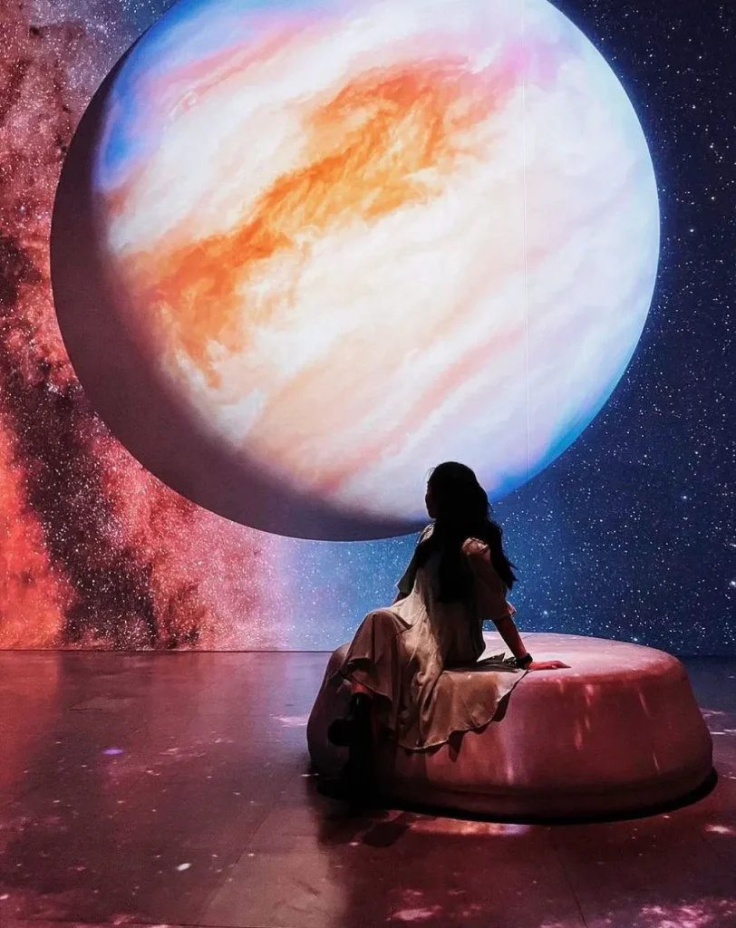 In questa foto una ragazza seduta all'interno di una delle stanze dell'Illuminarium di Las Vegas, negli stati uniti