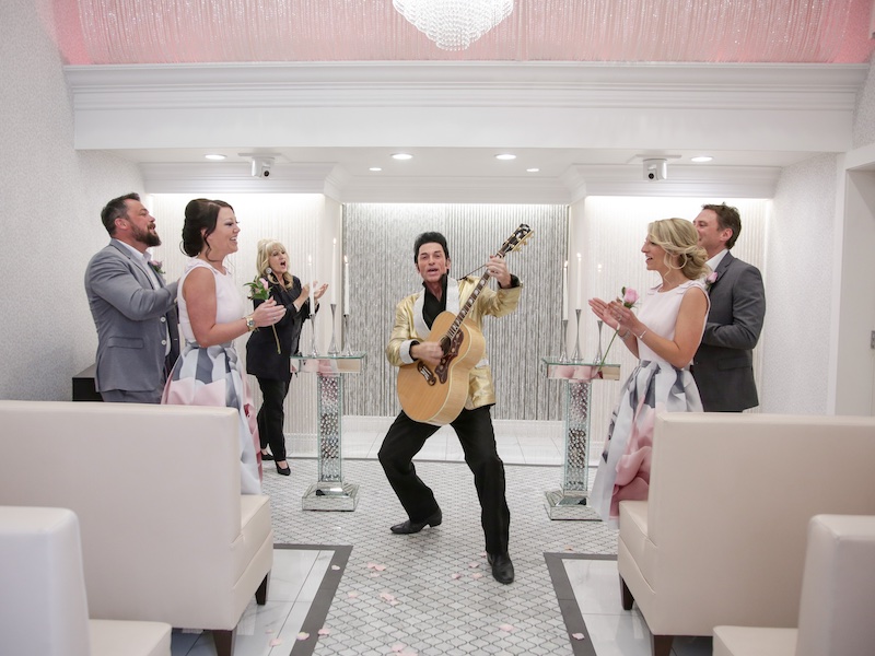 In questa foto, quattro invitati al matrimonio battono le mani in una Love Chapel di Las Vegas davanti ad un figurante che interpreta Elvis Prestley
