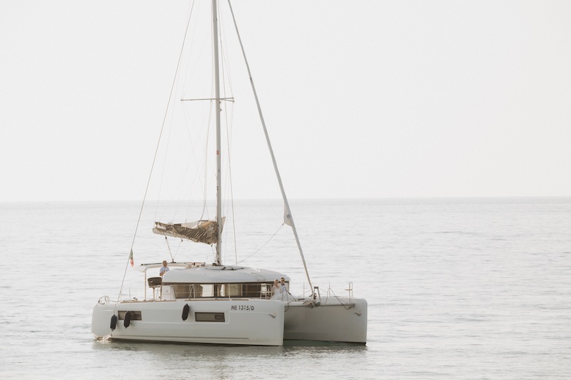 In questa foto, due sposi a bordo di un catamarano