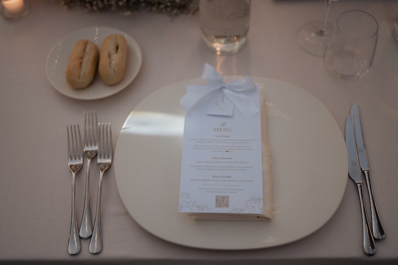 In questa foto, la mise en place con menù personalizzato di un matrimonio Total White