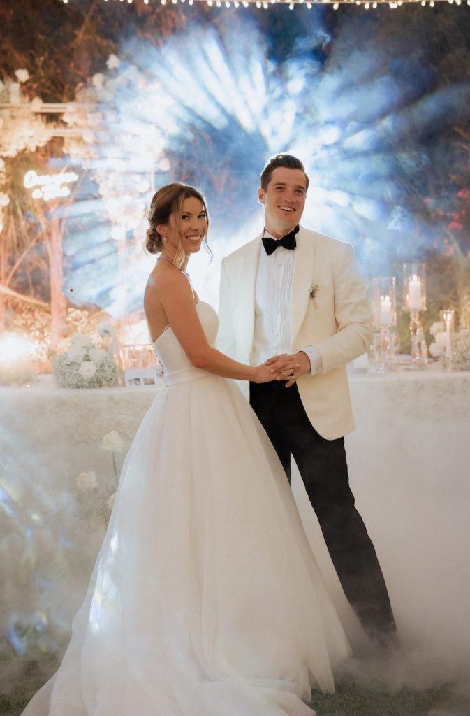 In questa foto, due sposi sorridono durante il loro primo ballo immerso in un nuvola di fumo