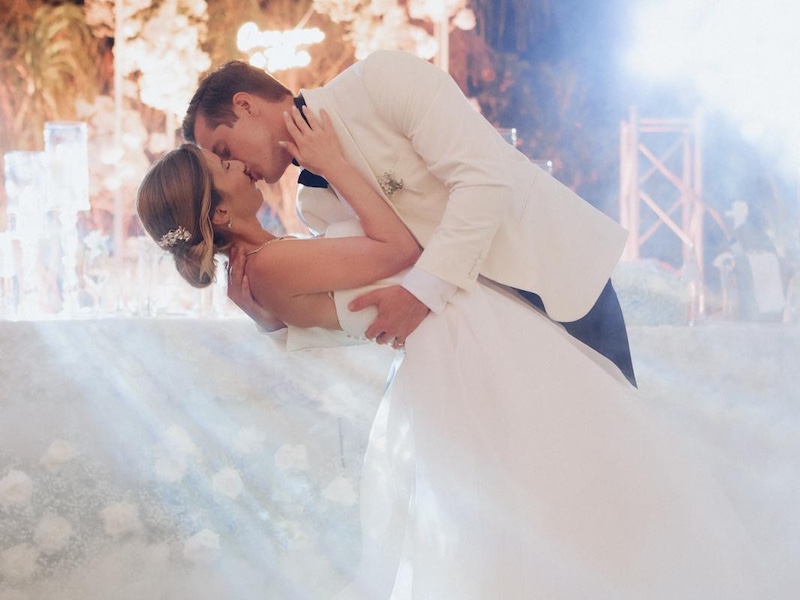 In questa foto, due sposi che si baciano durante il loro bacio in un matrimonio Total White firmato Fiorilandia Event Design