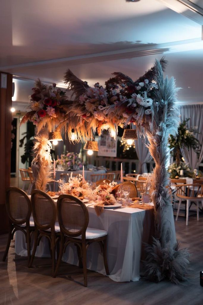 In questa foto, un tavolo matrimonio in stile boho chic con pampas e fiori di colore rosa allestito al mamamare