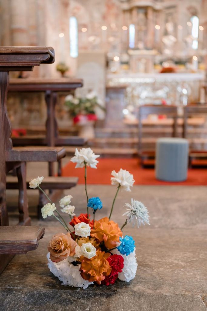 In questa foto, un dettaglio dell'allestimento floreale della  navata centrale della chiesa matrimonio di Sarah e Loris firmato Lovevery Weddings&Events 