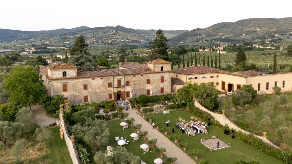 In questa foto del matrimonio di Emily e Mark firmato ester chianelli si vede una veduta panoramica della villa che ha ospitato l'evento. i giardini molto curati, l'allestimento elegante del ricevimento e l'imponenza del 