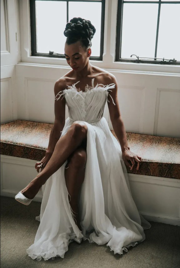 in questa foto si vede un'acconciatura sposa capelli lunghi acconciati con un raccolto alto con treccia