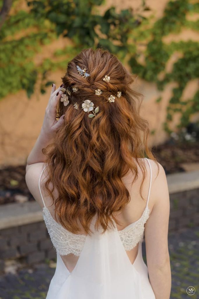 In questa foto, un'acconciatura da sposa semi-raccolta con fermagli a forma di fiori colorati