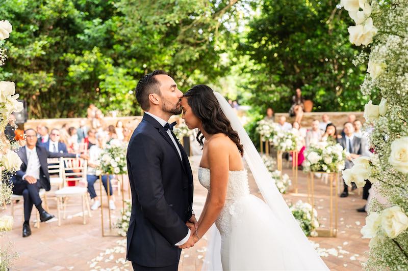 In questa foto, uno sposo bacia sulla fronte una sposa al termine della durante un matrimonio latino organizzato da Manuela Marrale