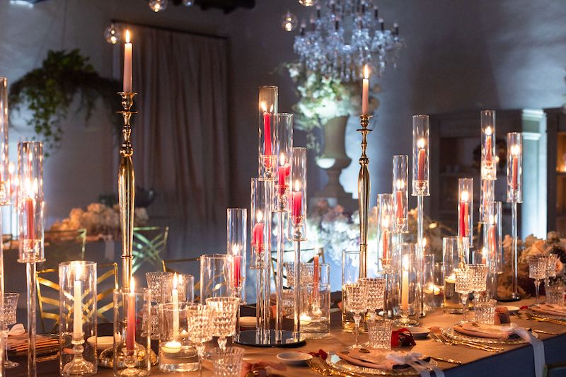 In questa foto, un dettaglio dell'allestimento del ricevimento di Barbara Vissani con un tavolo decorato con fiori bianchi e candele di diverse altezze 