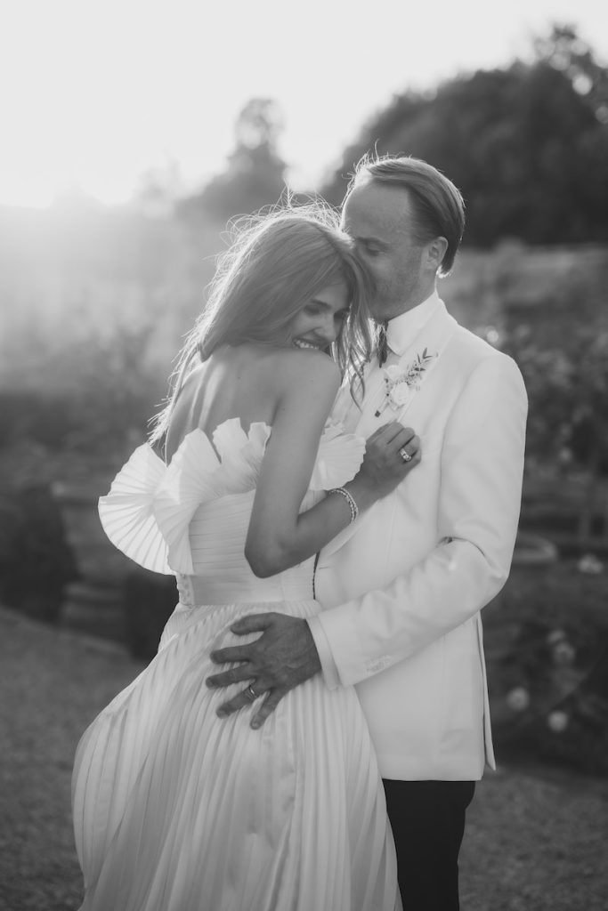 In questa foto in bianco e nero, un momento delle nozze di Melissa e Bob firmate da Corsini.Events: i due sposi sono abbracciati in uno dei viali di Villa Corsini a Mezzomonte