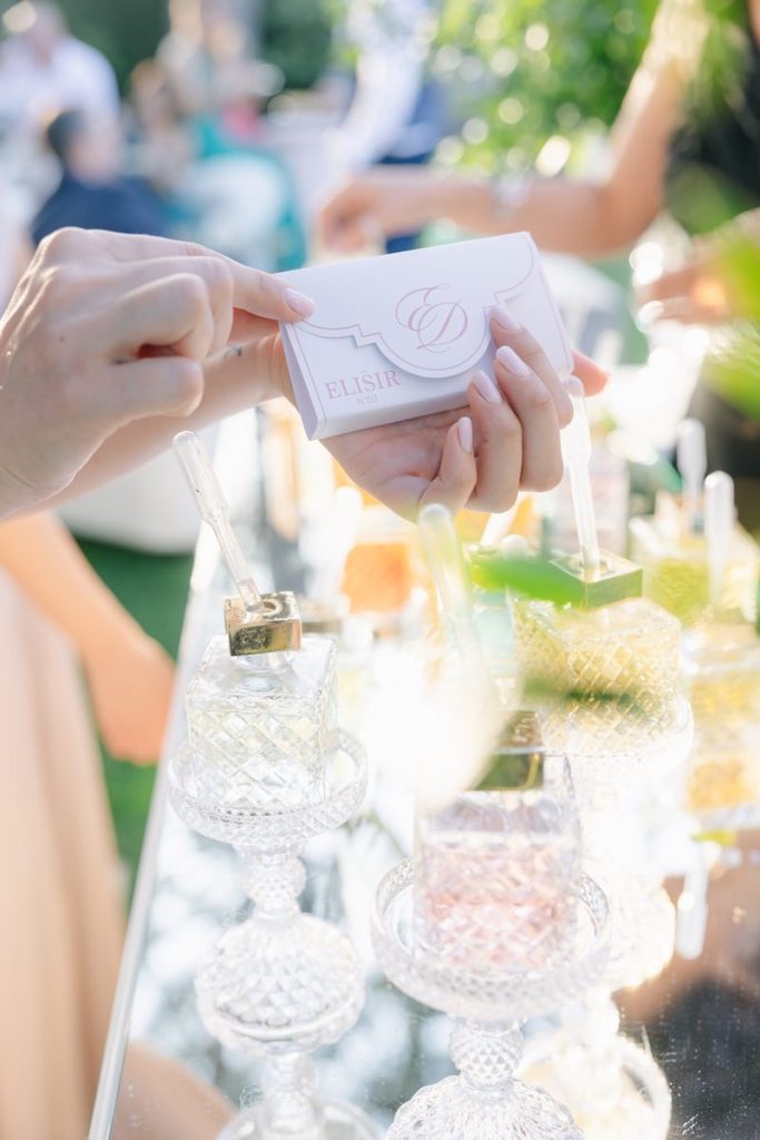 In questa foto, una box di carta di colore bianco con dettagli di colore rosa che contiene un profumo personalizzato di un matrimonio progettato da Giorgia Pirro