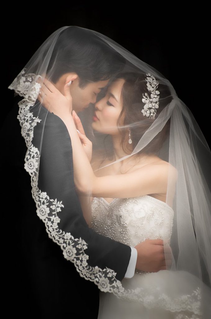 In questa foto Fine Art di Valeria Santoni due sposi abbracciati sotto al velo della sposa