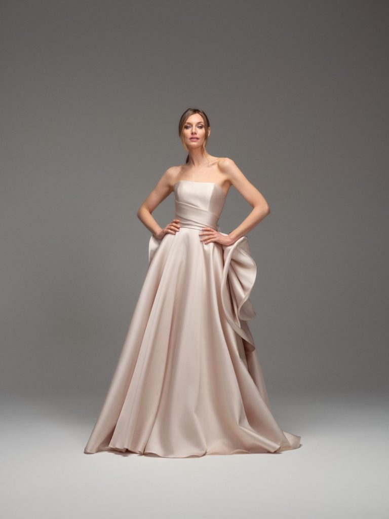 In questa foto, una modella indossa uno degli abiti da sposa Maria Pia Creazioni 2026 di colore rosa cipria, modello ad A con scollo dritto