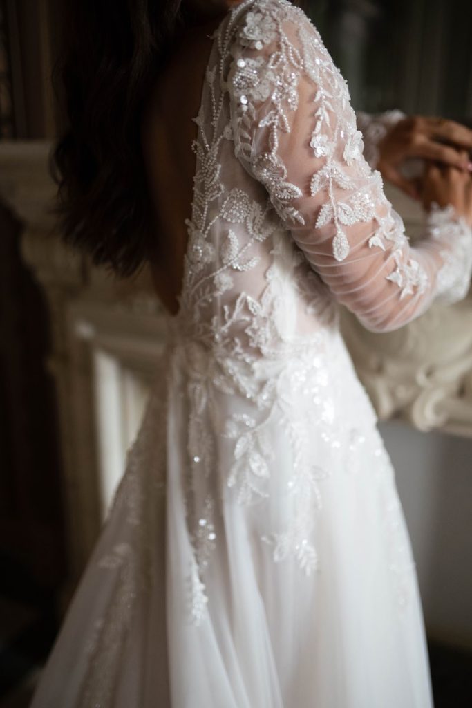 In questa foto, il dettaglio di un ricami di fiori realizzato con perline e paillettes, sulla manica di un abito da sposa