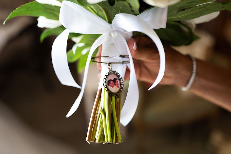 In questa foto, la fotografia dei nonni di una sposa attaccata al suo bouquet