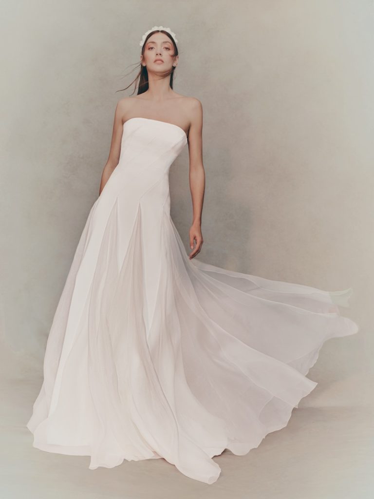In questa foto, una modella indossa un abito da sposa scivolato Pronovias 2026 con scollatura dritta e gonna in organza