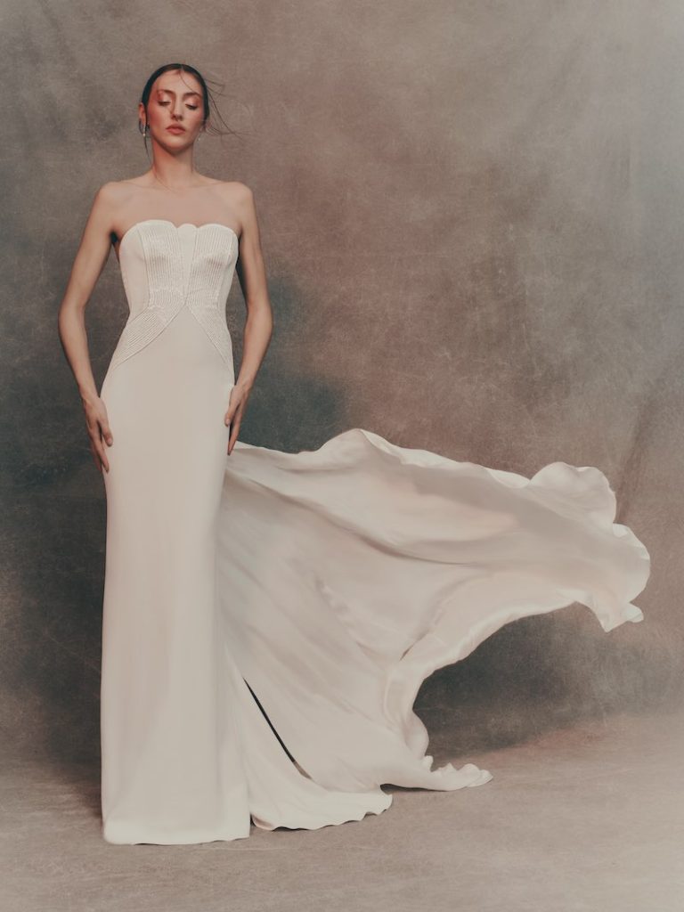 In questa foto una modella indossa un abito da sposa Pronovias 2026 modello a sirena, con lungo strasciso in cady 