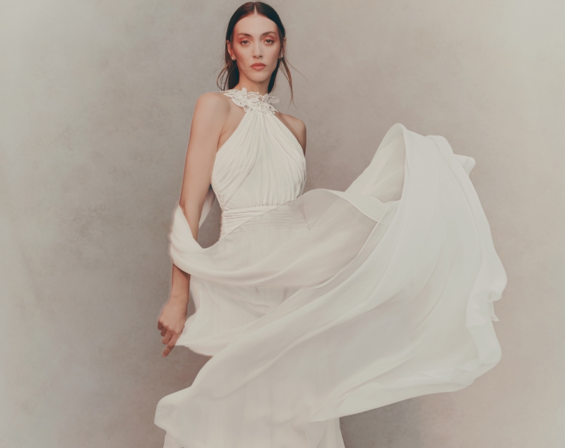 In questa foto, una modella indossa uno degli abiti da sposa Pronovias 2026 in organza con scollatura all'americana