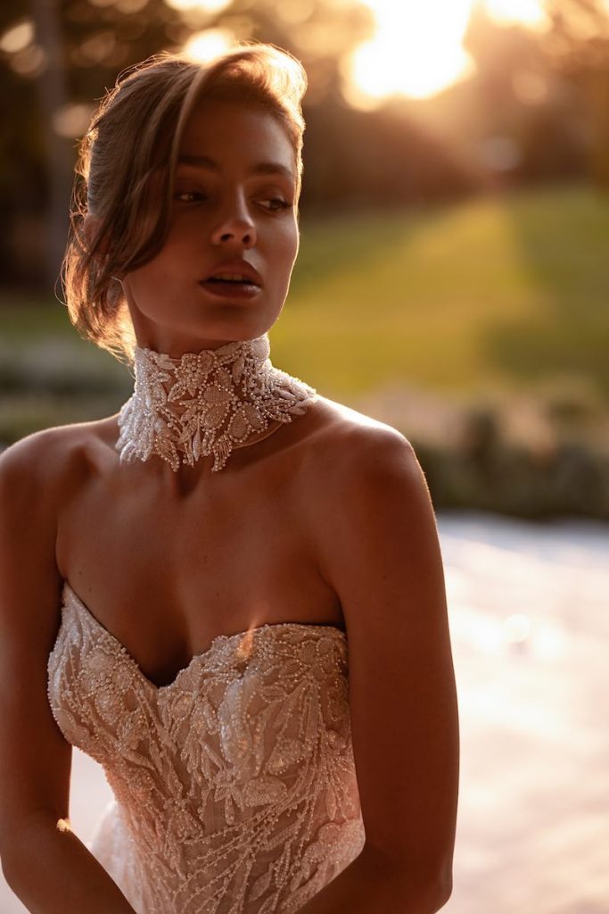 In questa foto, una modella posa indossando un choker da sposa ricamato di perline 