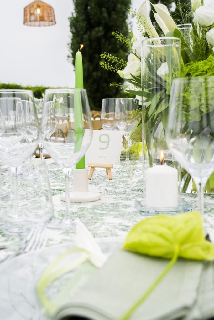 In questa foto, il dettaglio di uno dei tavoli del matrimonio di Alberto e Aldis firmato da Michele Squeri nei toni del bianco e del verde con candele e una piccola composizione floreale