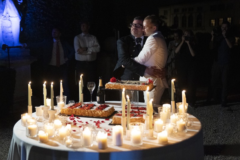 In questa foto il momento del taglio della torta del matrimonio di Alberto e Aldis. Il team di Michele Squeri ha decorato il tavolo con tante candele di altezze diverse