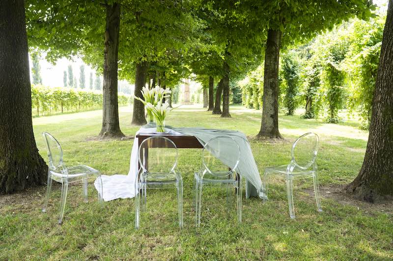In questa foto, l'allestimento del luogo della cerimonia realizzato da OttoQuattro Eventi con tovagliato nei toni del verde e con calle di colore bianco