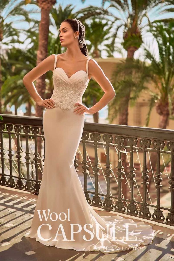 In questa foto, una modella posa indossando un abito da sposa Wool Capsule by Monica Loretti 2026 composto da gonna a semi sirena e corpetto ricamato con perline