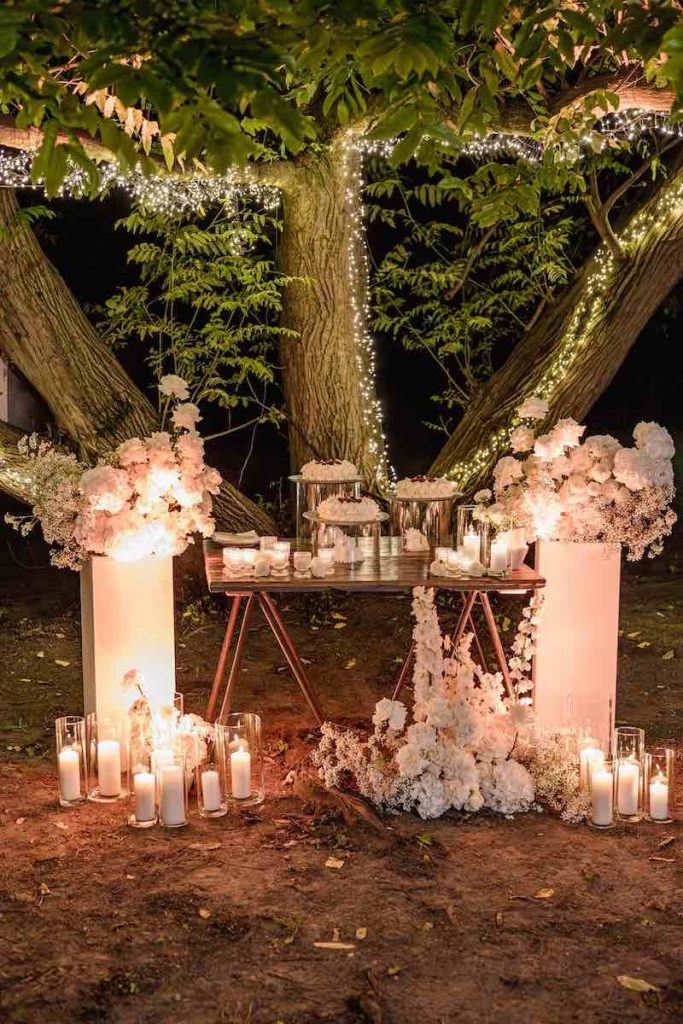 In questa foto l'allestimento di fiori bianchi per un buffet serale di dolci 