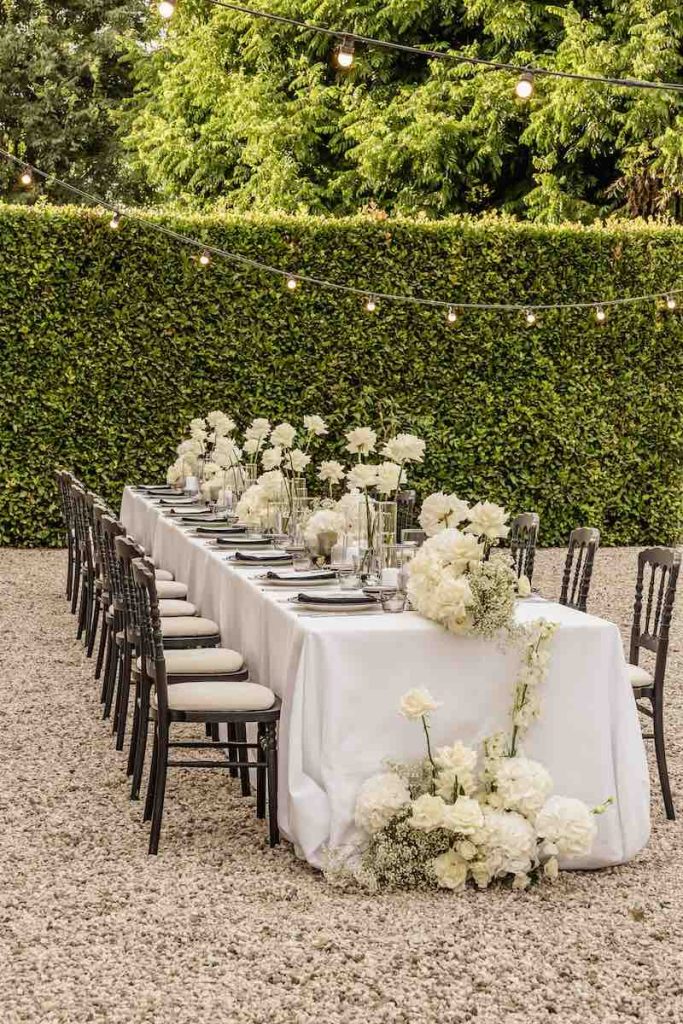 In questa foto un tavolo matrimonio allestito con fiori Total White per uno Small Wedding nel giardino di Villa Ormaneto